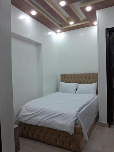 a bed with white sheets and pillows in a room at Aladdin Sphinx & Pyramid Stay in Cairo