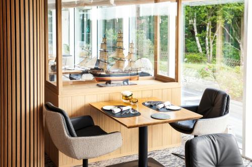 a room with a wooden table with a ship on it at Strandhotel Dünenmeer - Adults only in Dierhagen