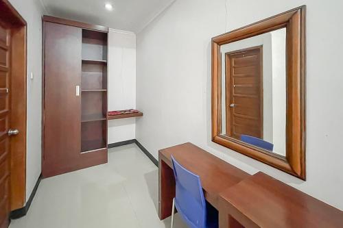 a room with a wooden table and a mirror at RedDoorz near Exit Toll Kalijati Subang in Pagon