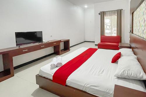 a bedroom with a large bed with a flat screen tv at RedDoorz near Exit Toll Kalijati Subang in Pagon