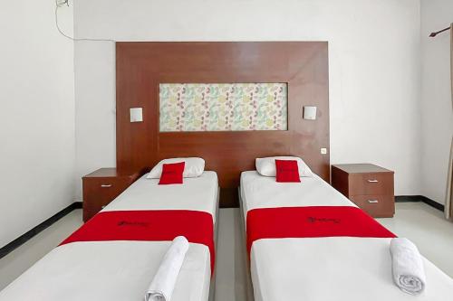 a room with two beds and a window at RedDoorz near Exit Toll Kalijati Subang in Pagon