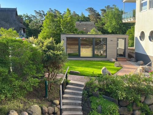 a garden with a small house with a backyard at Strandhotel Dünenmeer - Adults only in Dierhagen