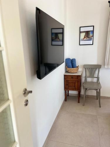 a room with a tv and a chair and a table at Tirza's Place in Livnim