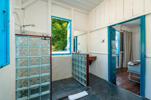 a bathroom with a sink and a shower with glass doors at Beach House Beau Vallon in Beau Vallon