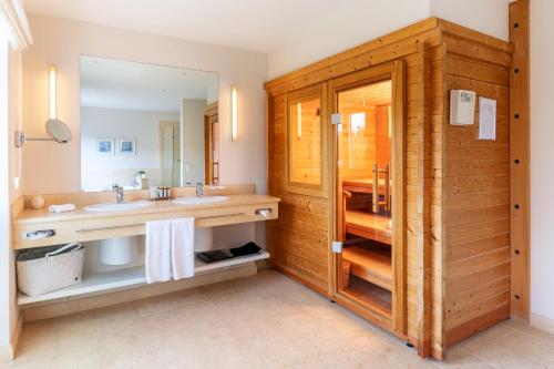 a bathroom with a sink and a mirror at Strandhotel Dünenmeer - Adults only in Dierhagen