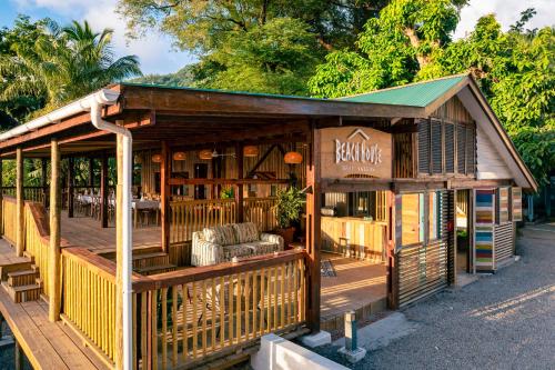 a wooden building with a porch and chairs at Beach House Beau Vallon in Beau Vallon