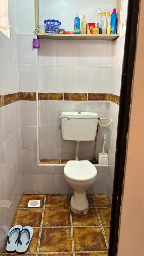 モンバサにあるMaweni Apartmentsのバスルーム(トイレ付)、床に靴を1足用意しています。