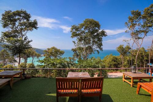a balcony with benches and a view of the ocean at Parinya Hill Homestay & Cafe Koh Larn in Ko Larn