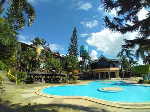 a large swimming pool in a resort with trees at La Traviesa Hotel Resort in General Trias