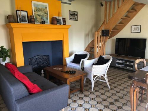 Una sala de estar con un sofá y una chimenea. en Le Côtier, en Margon