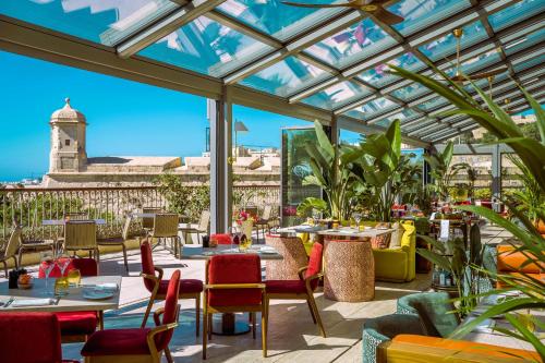 a restaurant with a glass roof with tables and chairs at The Phoenicia Malta - The Leading Hotels of the World in Valletta