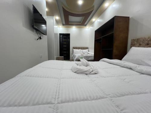 a large white bed with a towel on it at Aladdin Sphinx & Pyramid Stay in Cairo