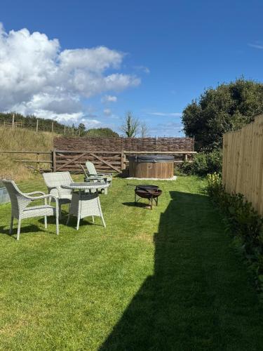 a backyard with a table and chairs and a grill at The Cabin at Salcombe Farm in Salcombe