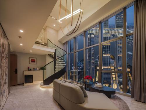 a living room with a couch and a large window at Ouchen International Sky River Hotel (Monument to the people's Liberation Pedestrian Street Store, Chongqing) in Chongqing