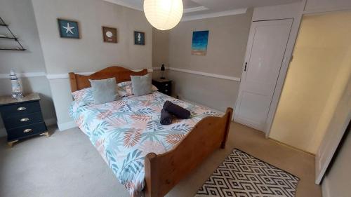 a bedroom with a bed with a blue and white comforter at Clifftop Mews - Westcliff - Ramsgate - Pet friendly! in Kent