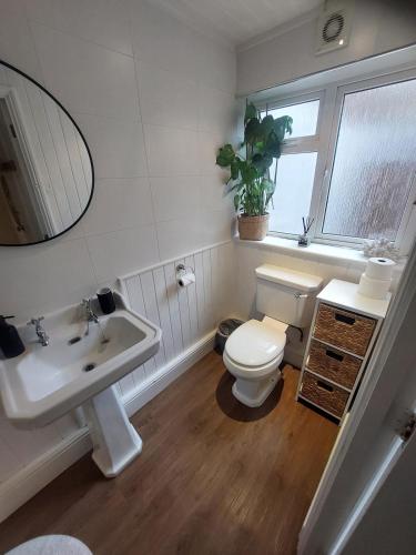 a bathroom with a toilet and a sink and a mirror at Clifftop Mews - Westcliff - Ramsgate - Pet friendly! in Kent