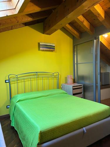 a bedroom with a green bed and a wooden ceiling at Borgo Santa Maria in Nembro