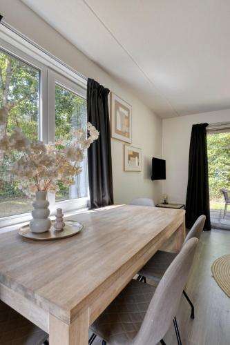 a dining room with a wooden table and chairs at Vakantiehuis - Brabantse gezelligheid met sauna VP098 in Hoeven