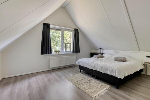 a white bedroom with a bed and a window at Vakantiehuis - Brabantse gezelligheid met sauna VP098 in Hoeven