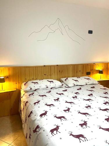 a bedroom with a bed with a mountain mural on the wall at Pink Grumello in Schilpario