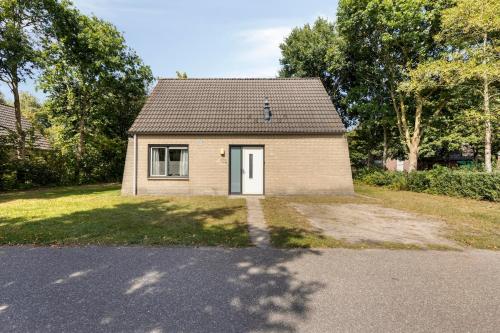 a small brick house with a white door at Vakantiehuis - Brabantse gezelligheid met sauna VP098 in Hoeven