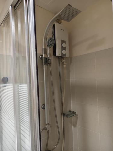 a shower with a shower head in a bathroom at Home style Staycation in Manila