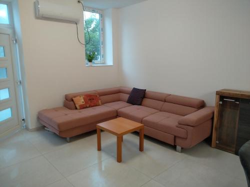 a living room with a brown couch and a table at Silver Dream Apartmanház in Debrecen
