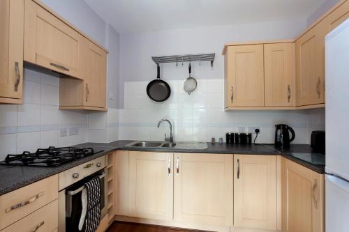 a kitchen with wooden cabinets and a sink at The Rampling's in Crawley