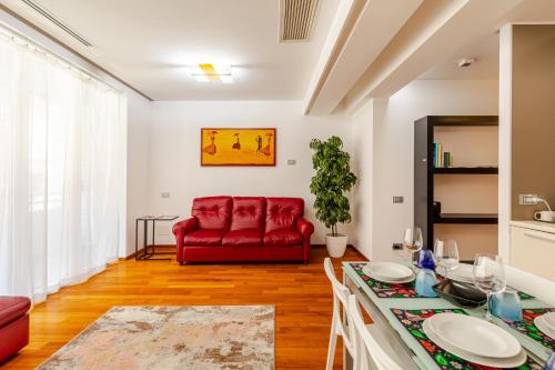 a living room with a red couch and a table at Modern Luxury Loft Porta Nuova - Parcheggio Privato in Turin