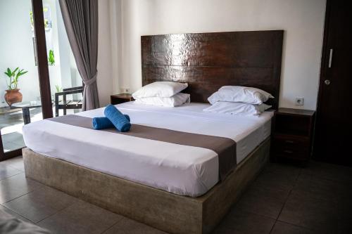 a bedroom with a large bed with a wooden headboard at Gili Ocean Club - ADULTS ONLY in Gili Trawangan