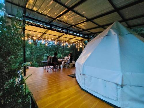 a tent with two people sitting at a table at Amornkeeree Khao Sok Camping in Khao Sok