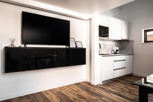 a living room with a large flat screen tv on a wall at Loft Prestige in Leiria