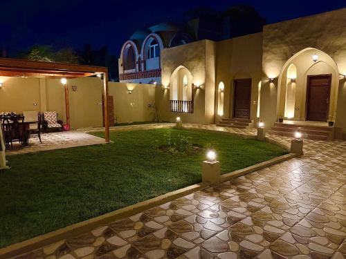 a courtyard of a house at night with lights at Bab Al Shams Palace in Luxor