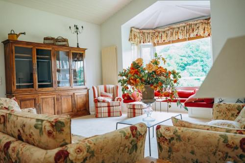 a living room filled with furniture and a large window at Chalet La Forestière in Saint-Paul-en-Chablais