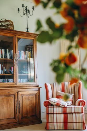 a living room with a cabinet and a chair at Chalet La Forestière in Saint-Paul-en-Chablais