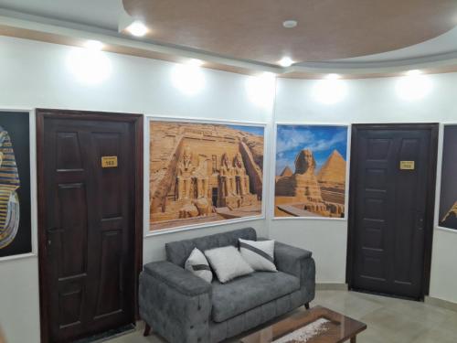 a living room with a couch and pictures on the wall at Aladdin Sphinx & Pyramid Stay in Cairo