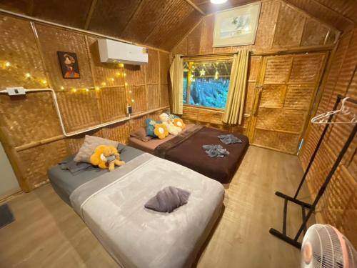 a small room with two beds and a window at Amornkeeree Khao Sok Camping in Khao Sok