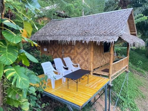 a gazebo with four chairs and a table at Amornkeeree Khao Sok Camping in Khao Sok