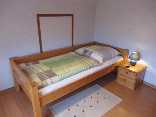 a small bedroom with a bed and a night stand at NEU! Ferienwohnung direkt am Deich in Neßmersiel