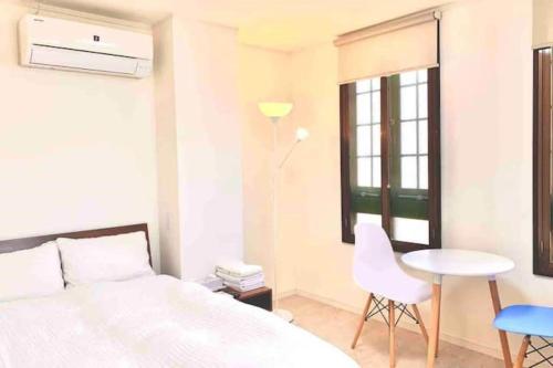 a bedroom with a bed and a table and chairs at R Inn 新井薬師前 in Tokyo