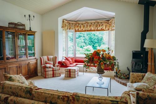 a living room with couches and a large window at Chalet La Forestière in Saint-Paul-en-Chablais