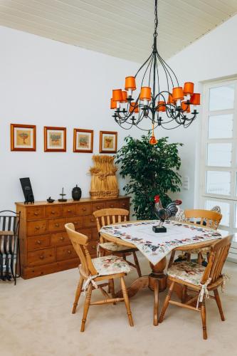 a dining room with a table with chairs and a chandelier at Chalet La Forestière in Saint-Paul-en-Chablais