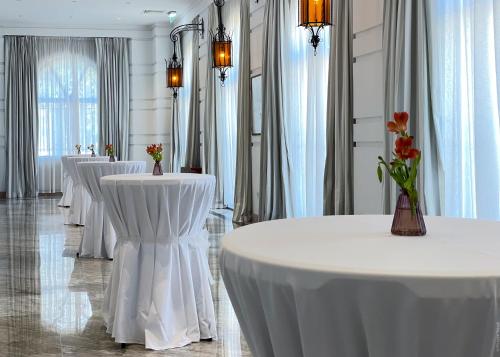 a row of tables in a room with white table cloths at The Phoenicia Malta - The Leading Hotels of the World in Valletta