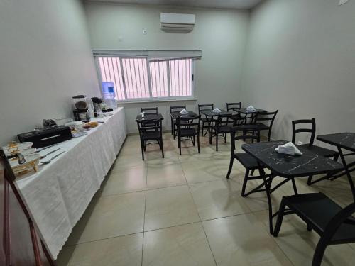 a restaurant with tables and chairs in a room at White Garden Hotel in Maputo