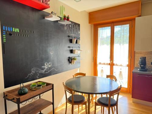 a kitchen with a table and a chalkboard wall at The Kaktus House - vicino San siro e Rho Fiera in Milan