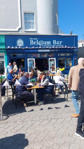 a group of people sitting at tables outside a restaurant at Clifftop Mews - Westcliff - Ramsgate - Pet friendly! in Kent