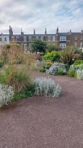 a garden with flowers and plants in front of a building at Clifftop Mews - Westcliff - Ramsgate - Pet friendly! in Kent
