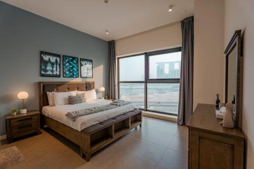 a bedroom with a large bed and a large window at Enjoy Scenic 1BR with BeachAccess Parking at Pixel504 in Abu Dhabi