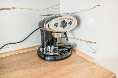 una macchina da caffè nera seduta su un pavimento in legno di Premium 1BR Free Parking APT Near Lake & Old Town a Ohrid