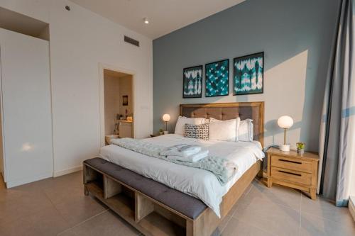 a bedroom with a large bed and two pictures on the wall at Enjoy Scenic 1BR with BeachAccess Parking at Pixel504 in Abu Dhabi